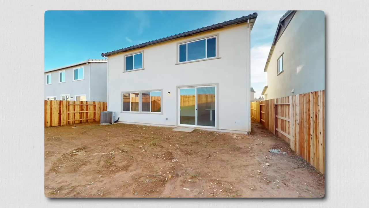 dirt backyard at new construction home with sliding glass door and wooden fence